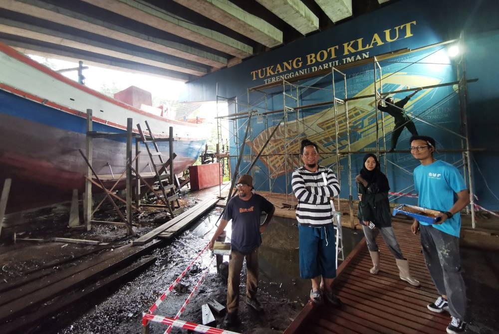 Dari kiri, Taib, Saufian, Nur Athirah, Khaidir Hakim (belakang) dan Aiman Faez di hadapan lukisan mural yang mendokumentasikan bahagian badan bot dalam bentuk diagram di Kampung Pulau Ketam, di Kuala Terengganu.