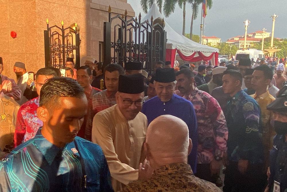 Anwar (tengah) bersalaman dengan orang ramai ketika tiba di Masjid Putra, Putrajaya sempena Munajat Ambang Tahun Baharu 2023 pada Sabtu.