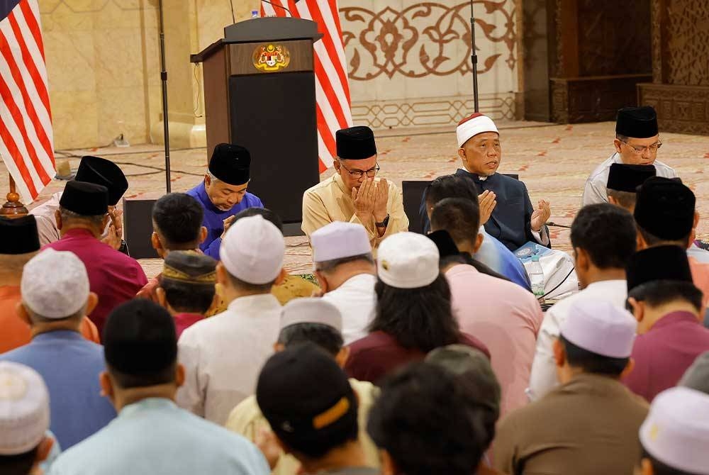 Anwar (tiga dari kanan) mengaminkan bacaan doa bersama jemaah yang lain semasa menghadiri program Munajat Ambang Tahun Baharu 2023 di Masjid Putra pada Sabtu. - Foto Bernama