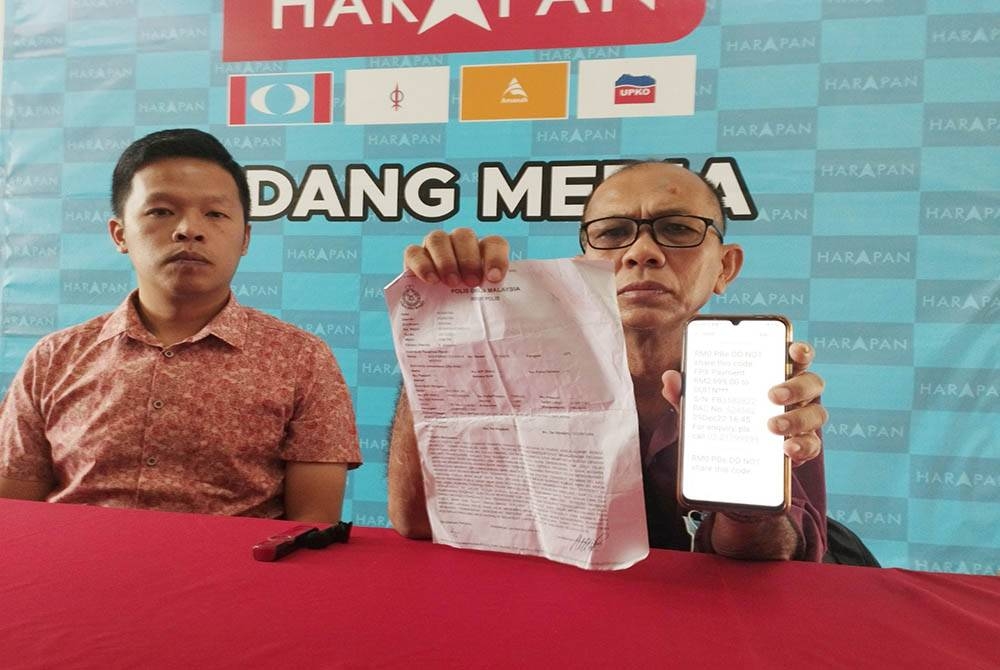 Yaw Jin (kanan) menunjukkan laporan polis dan nombor TAC yang diberikan kepada suspek sehingga menyebabkan wang simpanan hampir RM100,000 dalam akaun bank lesap pada Rabu lalu.