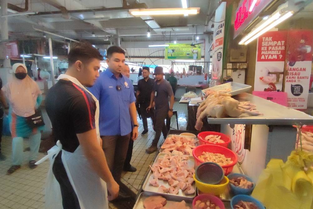 Mohamad Yusrizal (tengah) melakukan pemantauan harga barangan di Pasar Besar Alor Setar, di sini, pada Isnin.