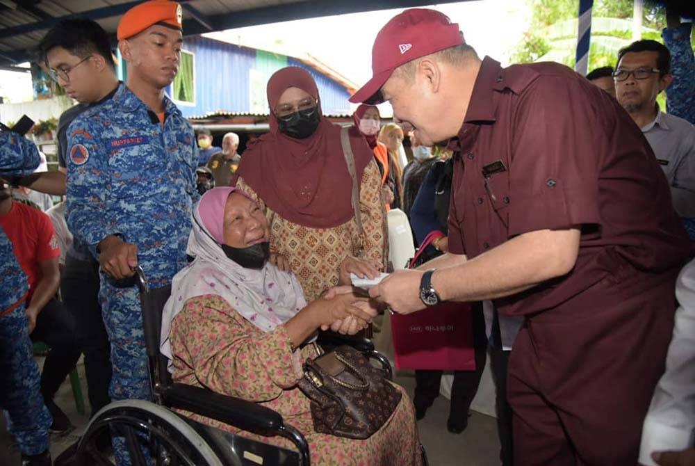 Hajiji menyampaikan bantuan ihsan daripada kerajaan negeri kepada penduduk yang terjejas selepas rumah mereka dipukul ombak dalam kejadian di Kampung Tanjung Aru Baru, Kota Kinabalu.