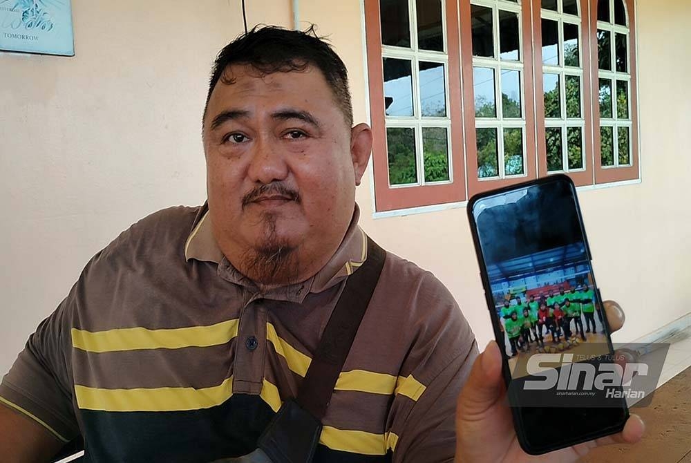 Abd Halim menunjukkan gambar anaknya bersama pasukannya dalam satu kejohanan bola tampar.