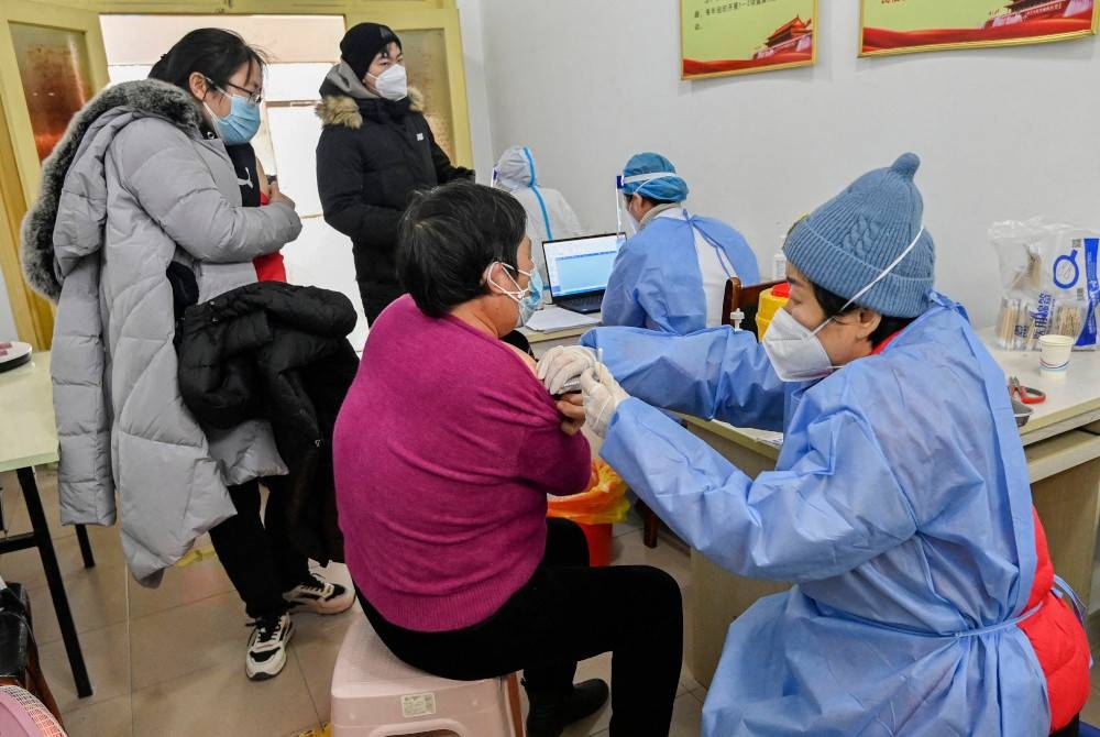 Seorang wanita menerima vaksin Covid-19 di Qingzhou, di wilayah Shandong timur China pada Khamis. - Foto AFP 