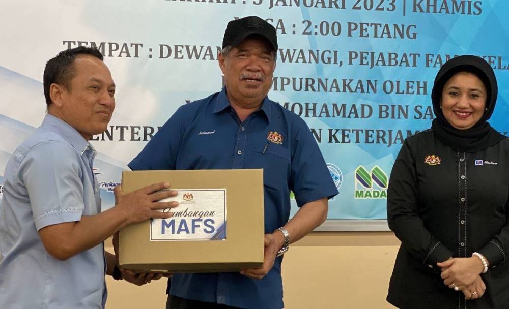 Mohamad (tengah) menyampaikan sumbangan kepada warga MAFS Kelantan pada Majlis Penyerahan Kit Bantuan Bencana Banjir di Pejabat FAMA, Kota Bharu pada Khamis.