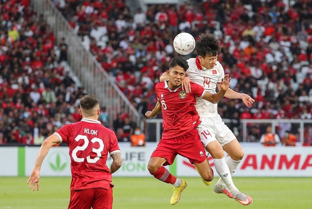 Pemain Indonesia, Marselino Ferdinan (tengah) menentang pemain Vietnam, Hoang Duc (kanan) semasa aksi separuh akhir pertama Piala AFF 2022 di Stadium Gelora Bung Karno di Jakarta. Foto EPA