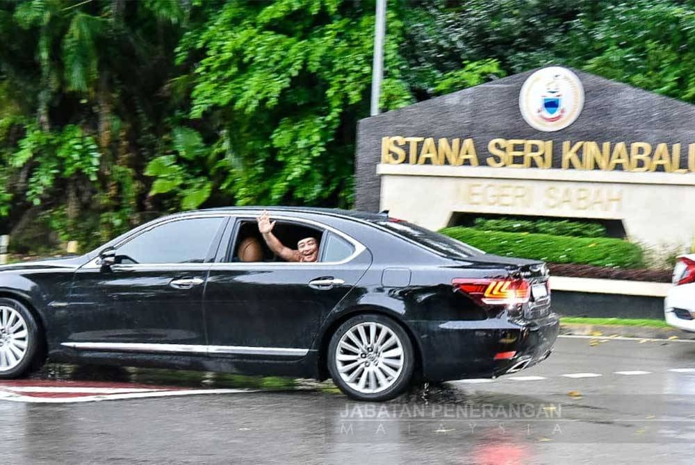 Hajiji memberikan lambaian kepada media di hadapan pintu gerbang Istana Seri Kinabalu di Kota Kinabalu.