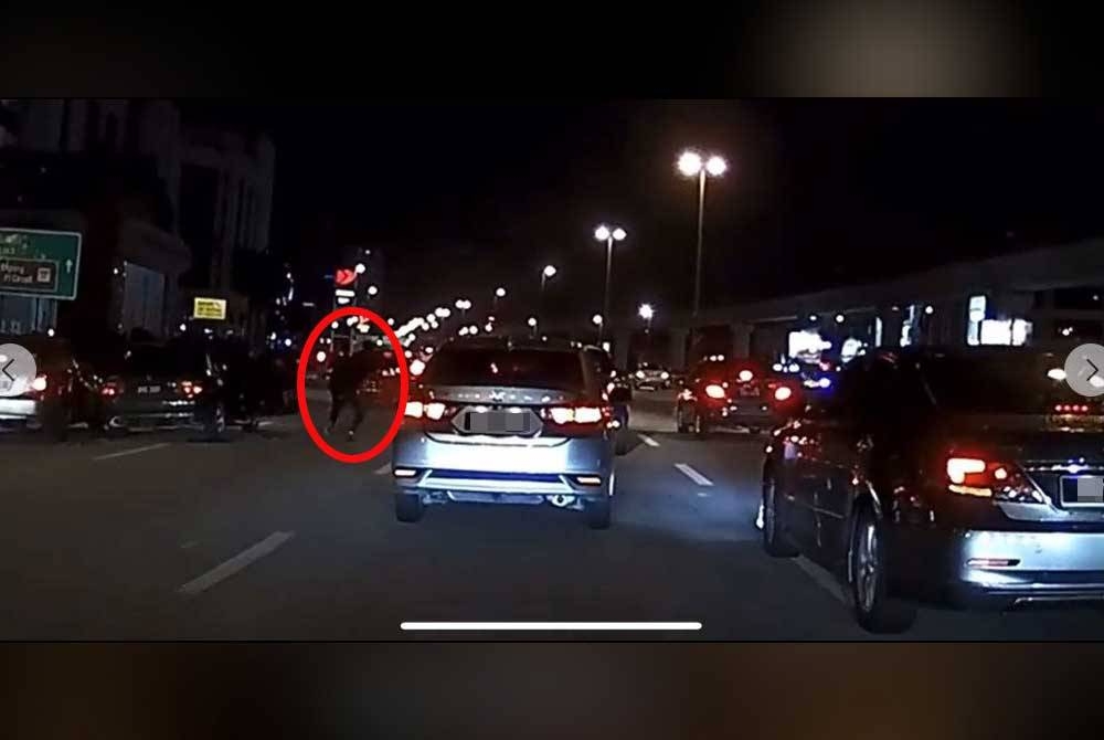 Rakaman video tular memaparkan beberapa individu berlari di tengah-tengah Lebuhraya Damansara-Puchong pada Jumaat. - Foto Facebook