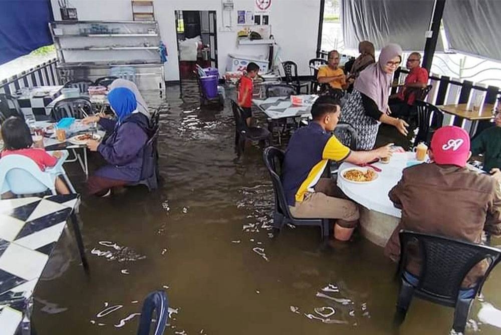 Norhayati (berdiri, kanan) melayan pelanggan yang berkunjung di Warung Bilal di Gong Badak, Kuala Nerus.