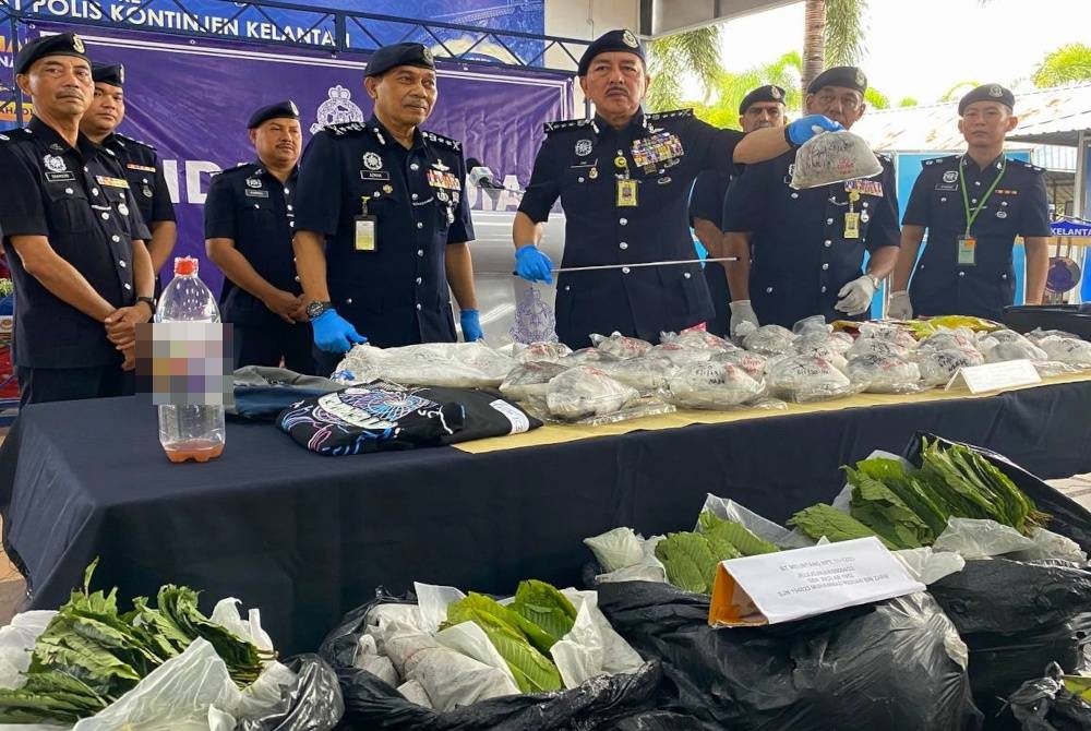 Muhamad Zaki (tiga dari kanan) menunjukkan bungkusan plastik cerah yang setiapnya berisi debu putih disyaki dadah jenis ketamin semasa sidang akhbar di IPK, Kota Bharu pada Ahad.