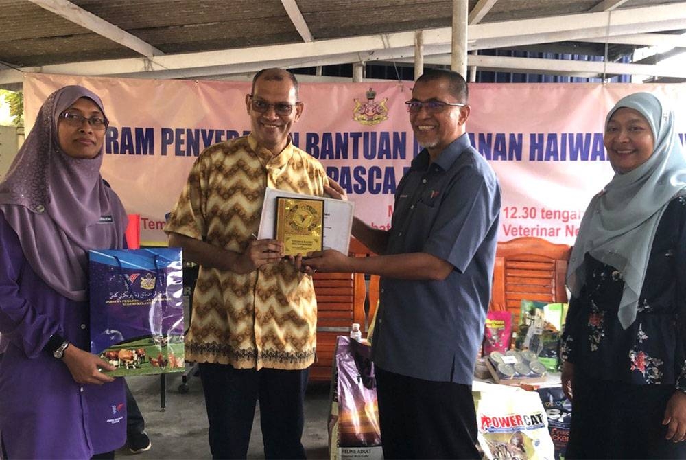 Dr Suratan (dua dari kanan) menyampaikan penghargaan kepada penyumbang makanan haiwan, Presiden Kelab Kucing Malaysia, Khalid Rashid (dua dari kiri).