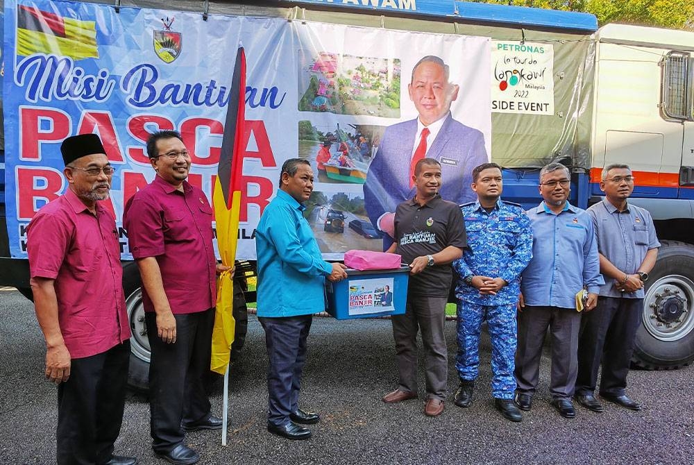 Aminuddin (tiga dari kiri) menyerahkan sumbangan untuk mangsa banjir Pantai Timur sebagai gimik pelepasan pada Isnin.