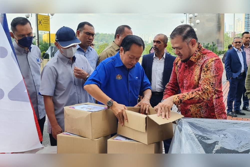 Ahmad Maslan (tiga dari kiri) bersama Fathul Bari (kanan) melihat pek sumbangan yang akan diagihkan kepada mangsa banjir di Kelantan dan Terengganu.