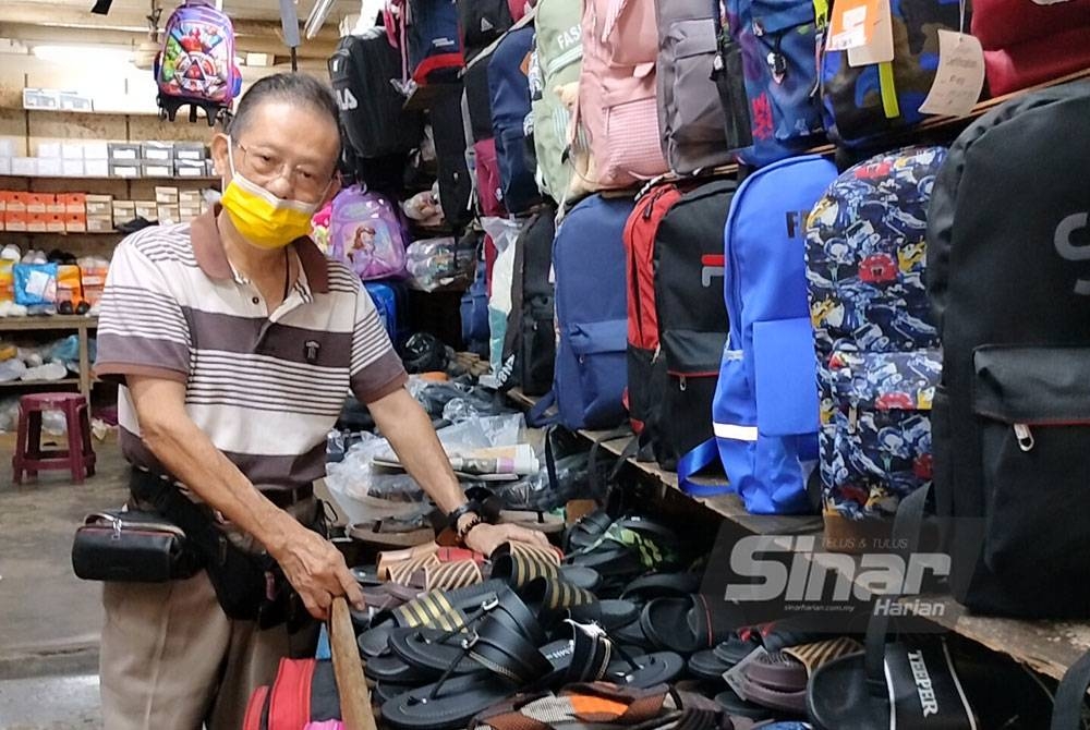 David Yeo menunjukkan sebahagian kasut dan selipar yang dijual di kedainya di Kampung Jawa pada Selasa.