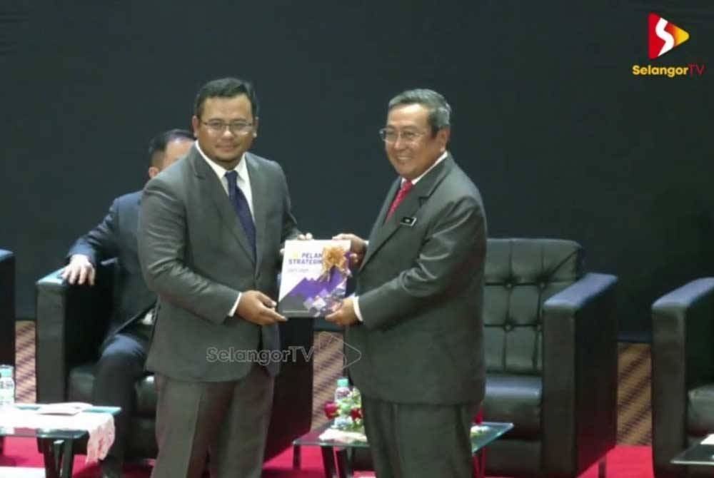 Setiausaha Kerajaan Selangor, Datuk Haris Kasim (kanan) menyerahkan Buku Pelan Strategik Pejabat Setiausaha Kerajaan Negeri Selangor kepada Amirudin (kiri) semasa Majlis Amanat Tahun Baharu 2023 di Auditorium Dewan Jubli Perak Bangunan Sultan Abdul Aziz di sini pada Rabu.