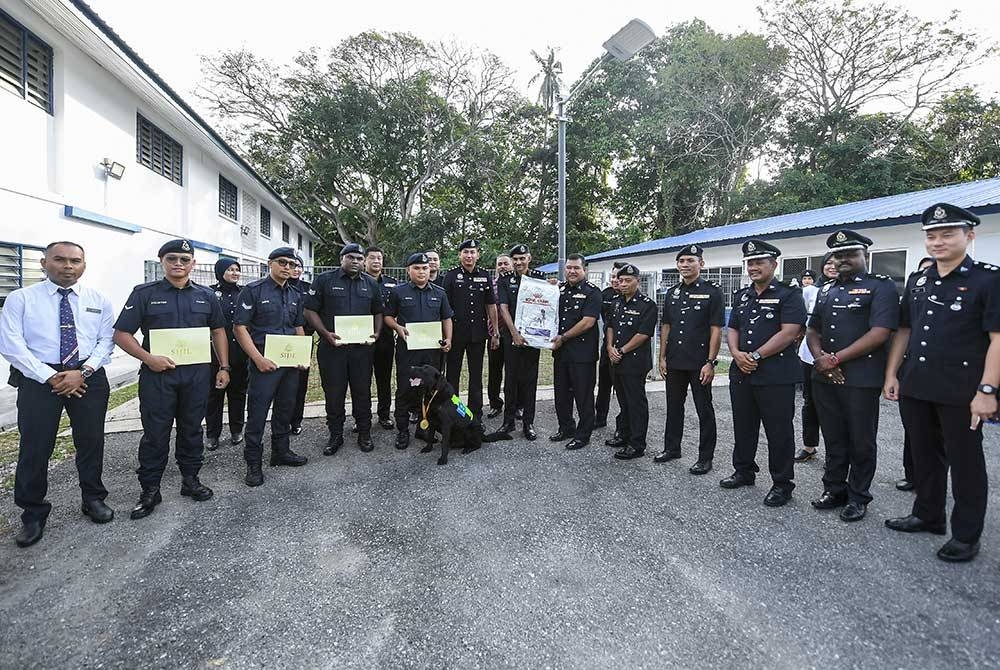 Suresh Kumar bergambar bersama para pegawainya selepas menyampaikan sijil penghargaan dan pingat kepada &#039;Black&#039; dan pengendalinya, Koperal Johan Anak Jame di Seksyen K9 pada Rabu. - Foto Bernama