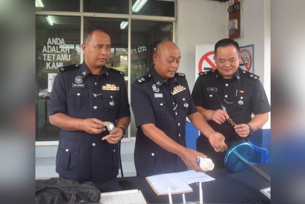 Hanyan (tengah) menunjukkan sebahagian barang yang dirampas polis.