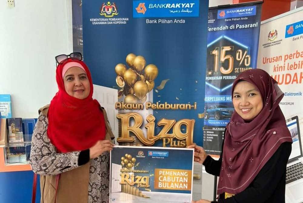 Rohana (kiri), salah seorang pelanggan Akaun Pelaburan-i Rizq Plus Bank Rakyat yang memenangi cabutan bulanan wang tunai RM5,000.