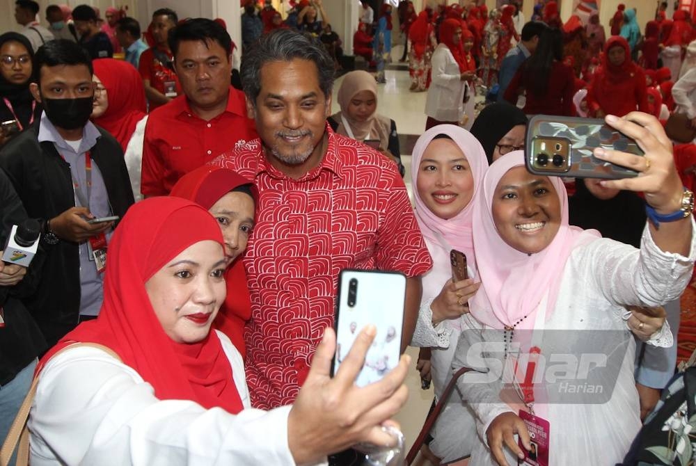 Khary Jamaluddin berswafoto dengan ahli UMNO ketika menghadirkan diri pada Perhimpunan Agung UMNO 2022 di Pusat Dagangan Dunia Kuala Lumpur. - Foto Sinar Harian ROSLI TALIB