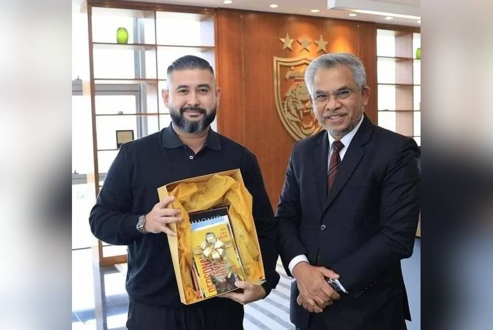 Mohd Daud (kanan) menghadiahkan beberapa buku tulisannya kepada Tunku Ismail pada Khamis. - Foto FB Mohd Daud