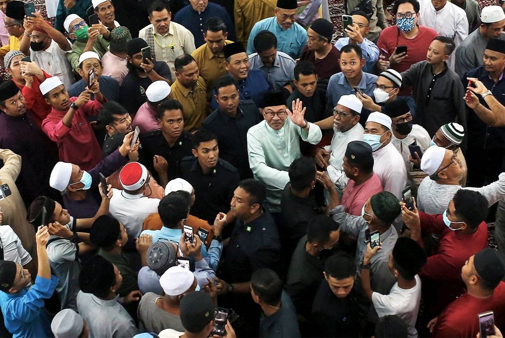 Anwar melambai tangan ke arah pengamal media selepas menunaikan solat Jumaat di Masjid Dato Klana Petra Mohd Yusof pada Jumaat.