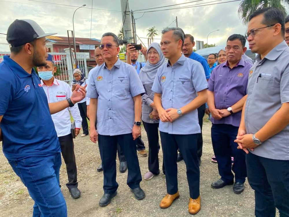 Fahmi (tiga dari kanan) beramah mesra dengan kakitangan KKD pada sesi perjumpaan bersama warga KKD Kelantan di Pejabat Jabatan Penyiaran Kelantan, Kota Bharu pada Jumaat.