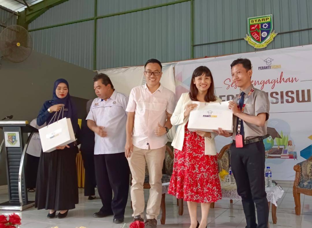 Nie Ching menyampaikan peranti kepada pelajar dalam Majlis Pengagihan PerantiSiswa Zon Selatan di SMK Tunku Abdul Rahman, Kulai, pada Ahad