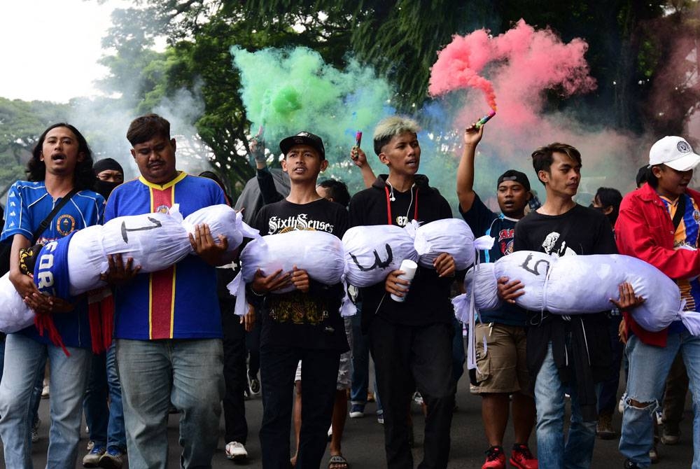 Peminat bolasepak mengadakan bantahan di Malang, Jawa Timur yang menyeru supaya pihak penganjur bertanggungjawab dalam insiden rempuhan maut pada Oktober 2022. - Foto AFP