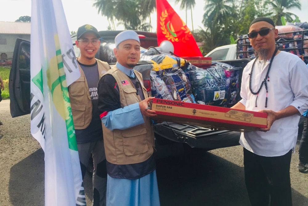 Mohamad Wadi Annuar (dua dari kiri) menyampaikan sumbangan kepada mangsa banjir di Tumpat.