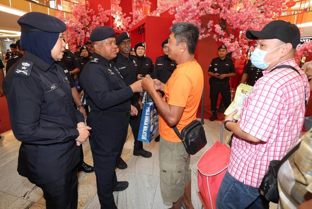 Kamarul Zaman edar buah limau dan risalah kempen kepada orang ramai pada Program Walkabout Kempen Rumah Selamat sempena Tahun Baru Cina di Midvalley Southkey hari ini. - Foto Bernama