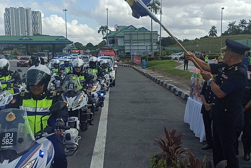 Mohd Edir (kanan) melepaskan anggota penguat kuasa JPJ Johor sempena operasi Tahun Baharu Cina di Tol Kempas pada Rabu.