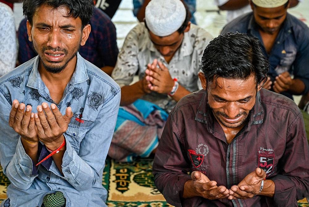 Pelarian Rohingya berdoa di penempatan sementara di Ladong, Aceh. - AFP