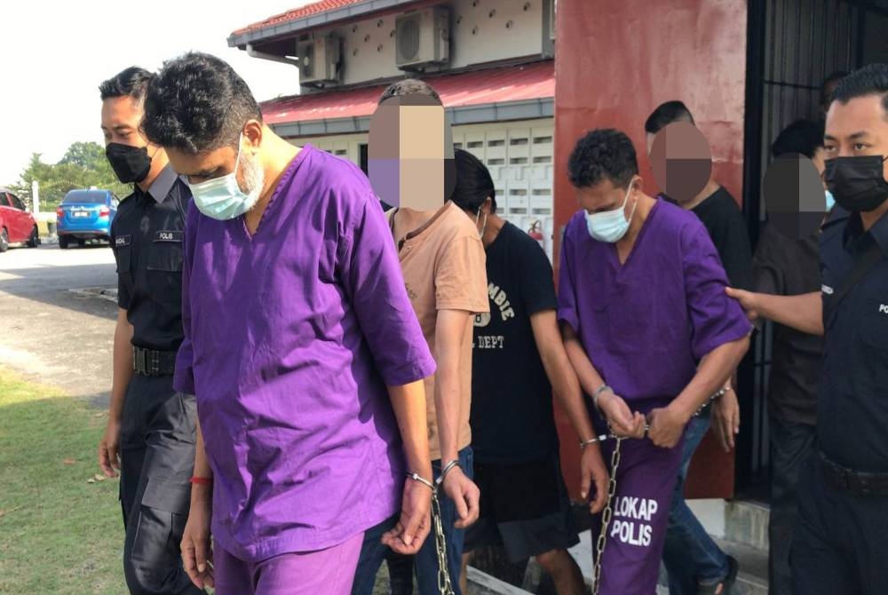 Dua beradik yang memakai baju lokap ungu dibawa keluar dari Mahkamah Majistret Kampar pada Khamis selepas selesai pertuduhan bagi kesalahan mengedar heroin.