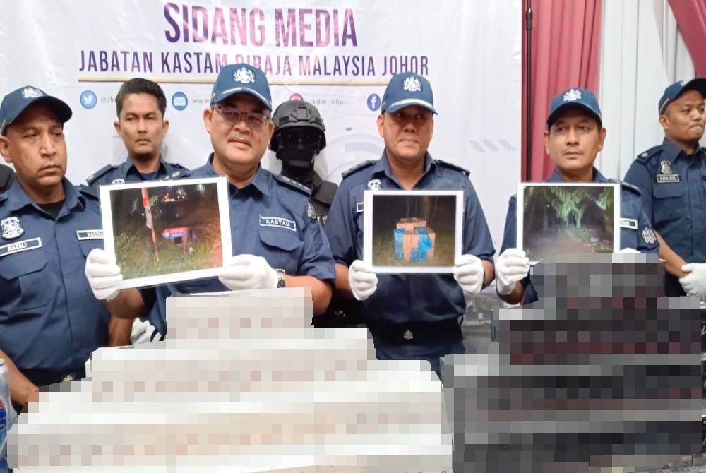 Misbahudin menunjukkan gambar lokasi rokok seludup yang dirampas dan sebahagian rokok kretek selepas sidang akhbar di Menara JKDM Johor, Larkin, Johor Bahru pada Khamis.