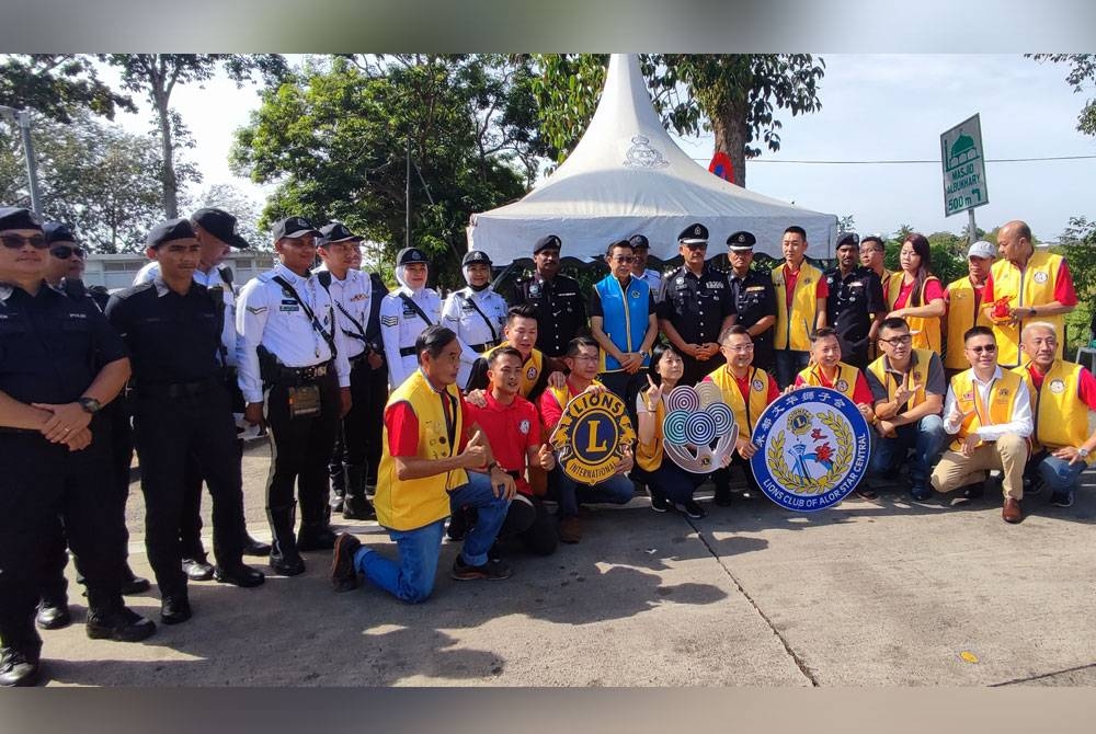 Ahmad Shukri (tengah) bersama bersama anggota bertugas dan ahli Kelab Lions Alor Setar selepas pemeriksaan kenderaan dan pemberian cenderahati kepada pengguna di Plaza Tol Alor Setar Utara, Alor Setar, pada Khamis.