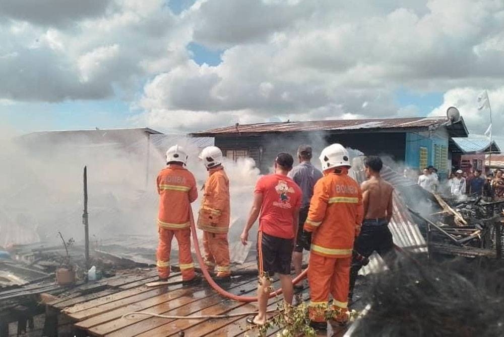 Bomba sedang memadam kebakaran rumah di Kampung Bangau-Bangau pada pagi Khamis.