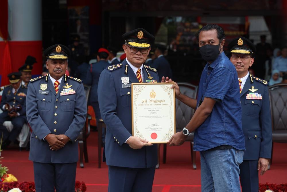 Mohammad Hamdan menyerahkan sijil penghargaan kepada Ahmad Ismadi pada Majlis Perbarisan Tahunan 2023.