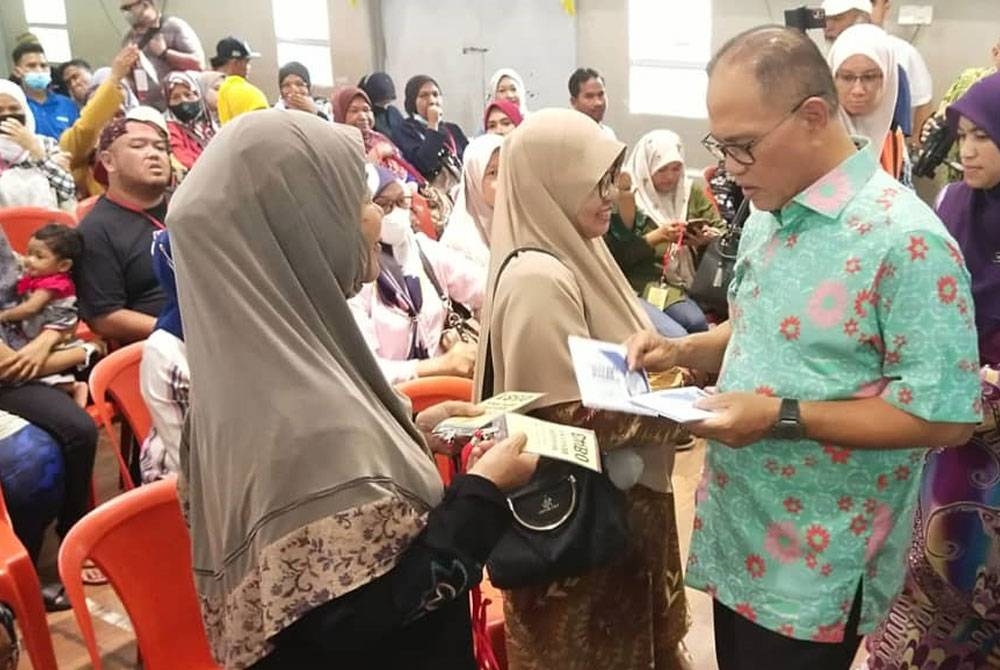 Wan Rosdy menyampaikan bantuan wang ihsan kepada KIR mangsa banjir daerah Kuantan pada majlis penyerahan di dewan SK Pelindung di Kuantan pada Khamis.