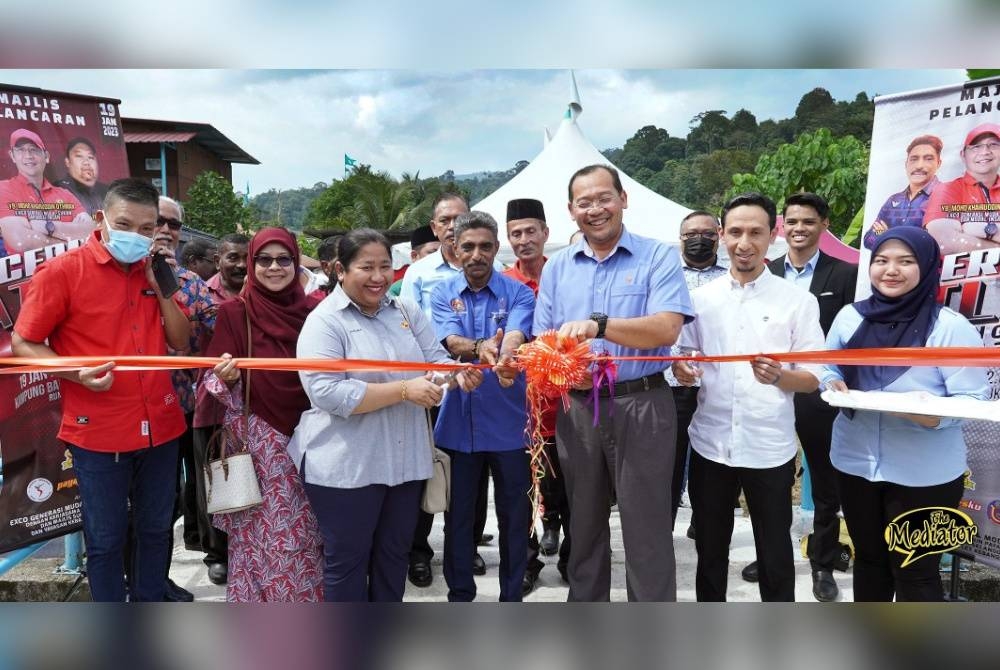 Mohd Khairuddin (tiga dari kanan) memotong riben sebagai simbolik penyerahan geran tanah kepada salah seorang penerima semasa Program Ceria Atlet Selangor di Kampung Bahagia, Bukit Lagong pada Khamis.