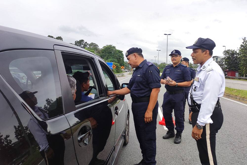 Hasmerra memberi maklumat kempen Ops Selamat 19 sempena Tahun Baharu Cina kepada pengguna jalan raya di Ajil pada petang Khamis.