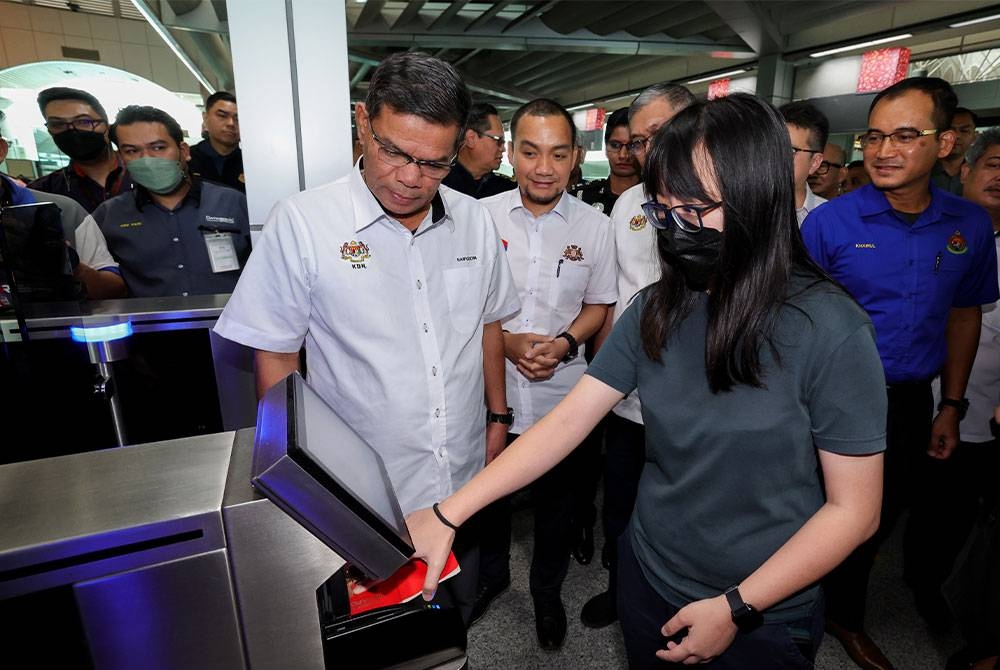 Datuk Seri Saifuddin Nasution Ismail (kiri) melihat seorang pengembara warga Singapura menggunakan mesin pengimbas Malaysia Automatet Clearance System (MACS2.0) pada siri lawatan kerja di Bangunan Sultan Iskandar pada Jumaat. - Sinar Harian.