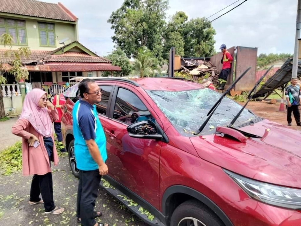 Andansura melihat kerosakan kenderaan yang dialami oleh salah seorang mangsa kejadian pokok tumbang pada petang Khamis.