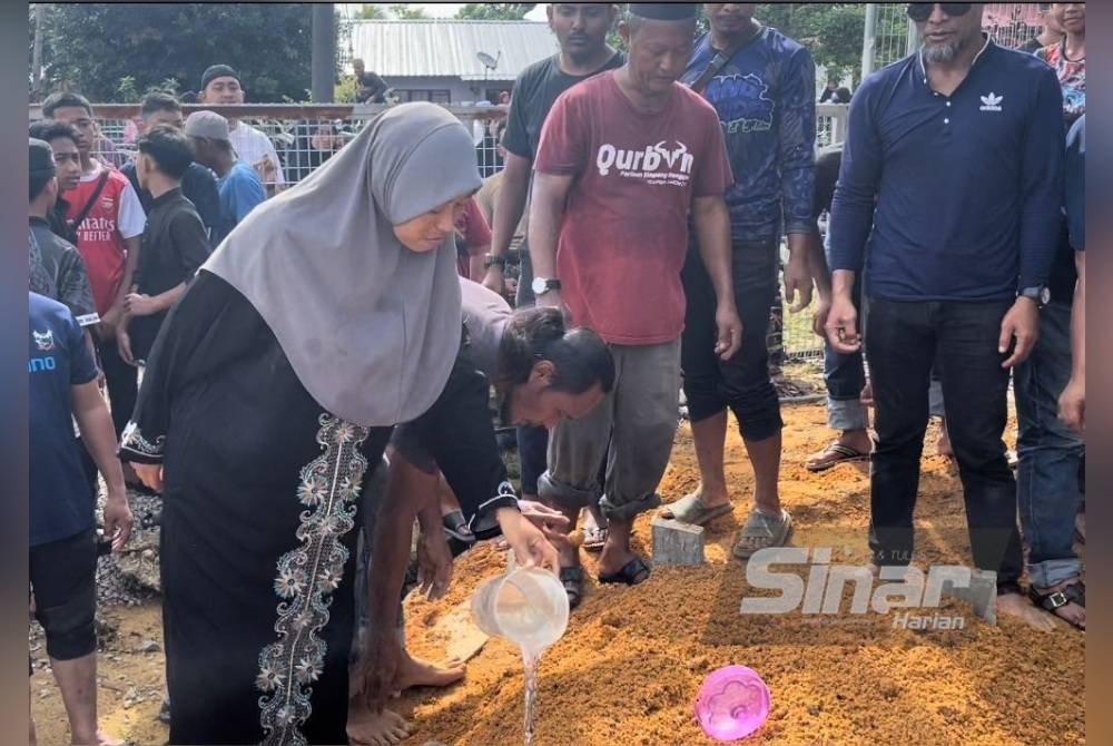 Ana dan Noramin menyiram air di tanah perkuburan kedua anaknya pada Ahad.