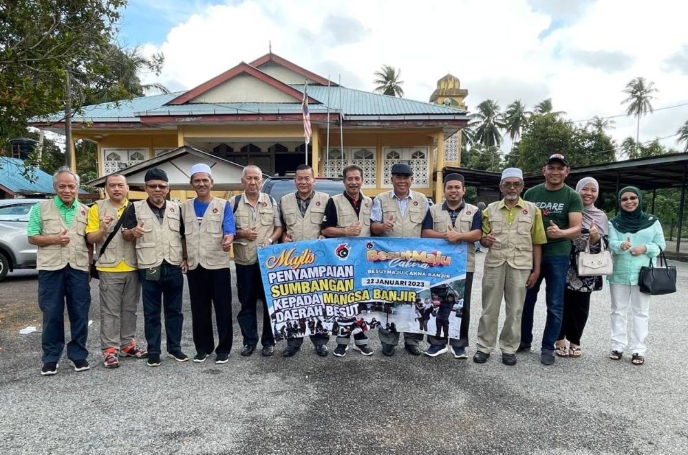 Hazmin (tengah) bersama Mohd Nawawi (enam dari kanan) dan Muhammad Nasir (kiri) ketika hadir pada program agihan sumbangan mangsa banjir yang di sampaikan di Masjid Kampung Pondok Paku, Kerandang, di Besut pada Ahad.
