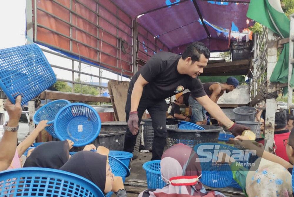 Pelanggan menghulurkan bakul kepada Shahmiazani yang berada di atas lori untuk mendapatkan durian. - FOTO: SINAR HARIAN