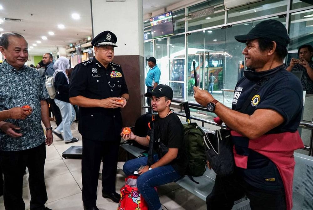 Azizi menyantuni orang ramai sempena Kempen Kesedaran dan Keselamatan Jalan Raya Masyarakat Pulang ke Kampung sempena Tahun Baharu Cina bersama Perkeso Perak di Terminal Meru Raya, Ipoh pada Selasa.