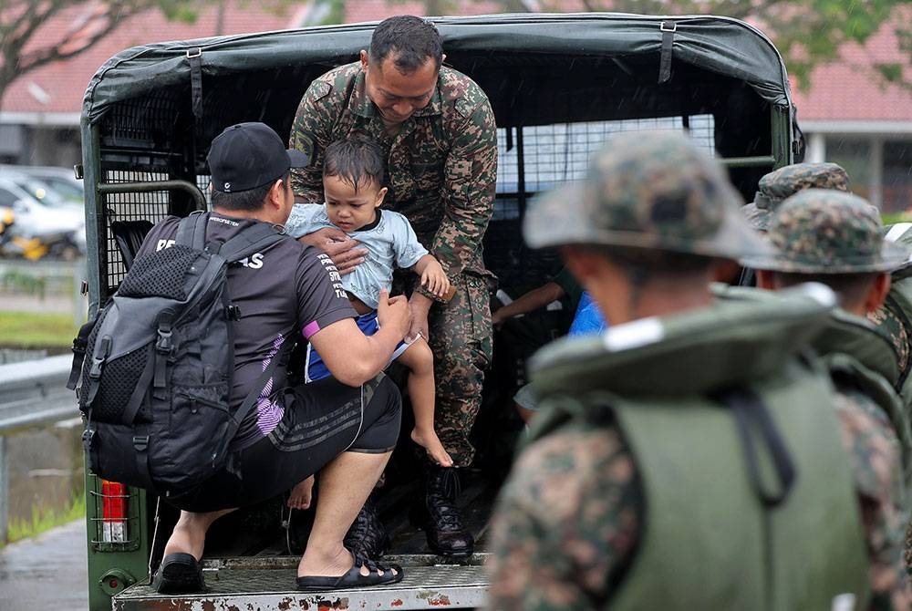 Anggota tentera membantu memindahkan mangsa banjir di Taman Desaru Utama, Bandar Penawar pada Selasa. - Foto Bernama