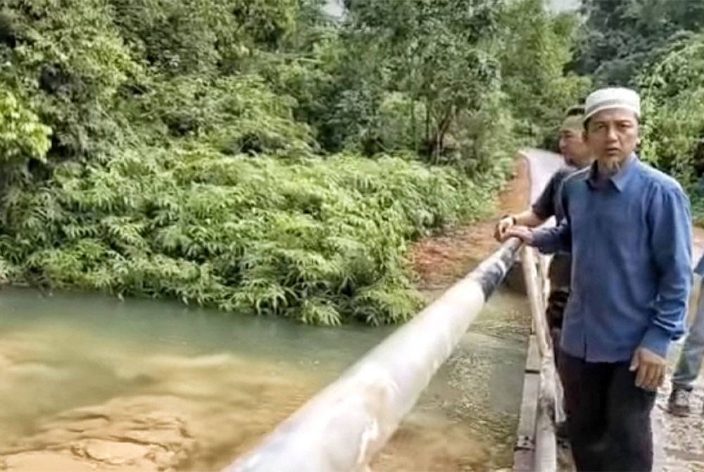 Nazri (depan) meninjau air Sungai Tepesuk selepas menerima aduan daripada penduduk pada Selasa