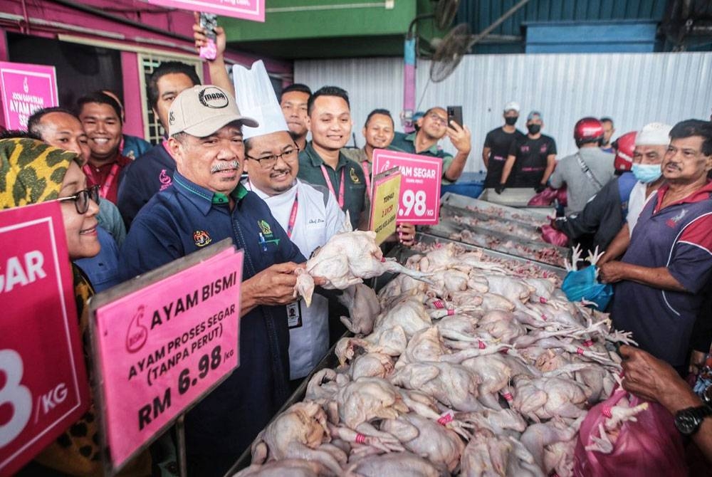 Mohamad (kiri) menunjukkan ayam segar yang dijual ketika mengadakan lawatan ke Pusat Jualan Ayam Bismi di Simpang Empat di sini pada Rabu.