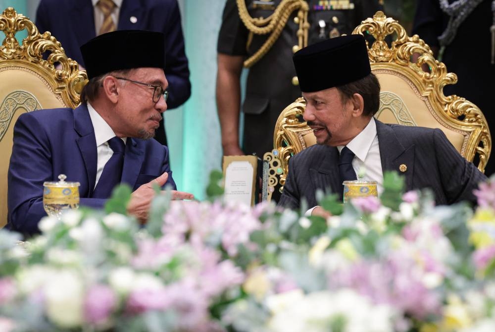 Anwar (kiri) beramah mesra dengan Sultan Hassanal Bolkiah pada Majlis Persantapan Rasmi di Istana Nurul Iman hari ini. - Foto Bernama